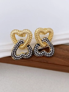 Detailed close-up of double interlocking hearts earrings with gold and pavé zircon finish