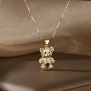 Close-up of golden bear pendant with sparkling white pavé and blue center stone