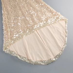 Detail of elegant champagne gold sequin fabric with smooth inner lining for evening dress