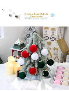 Close-up of assorted flocked Christmas balls hanging on a snow-covered tree