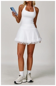 Detailed view of white racerback yoga top and layered mesh skirt with professional fit