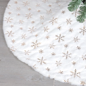 Détail d'une jupe de sapin de Noël en peluche blanche avec broderie de flocons dorés