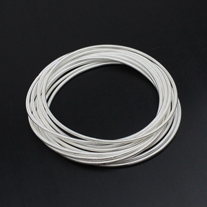 Macro detail of 1.7mm silver carbon steel guitar string spring coils with spiral texture