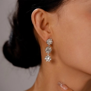 Close-up of elegant silver sunflower earrings with sparkling rhinestones on model