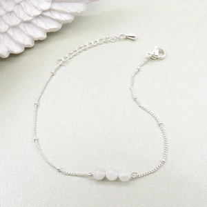 Detailed shot of silver-plated bead bracelet with three natural white moonstones and lobster clasp