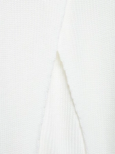 Detailed close-up of side slit and fine knitted texture on white high neck sweater