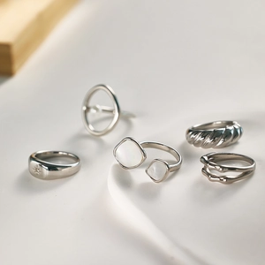 Detailed close-up of a five-piece vintage silver steel ring set with diverse textures