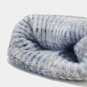 Gros plan du bonnet en maille tie-dye bleu et gris montrant la texture douce