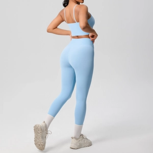 Rear view of light blue yoga set featuring thin straps and high-waisted leggings on model
