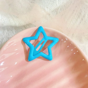 Macro shot of sky blue star hair clip on pink shell texture plate with white lace