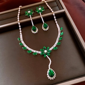 Detail shot of vintage flower jewelry set with green gemstones in a jewelry box