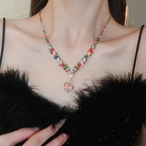 Close-up of vibrant multi-colored rhinestone necklace with a pink heart pendant on a model