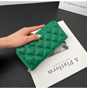 Detail of green patent leather long wallet with quilted pattern and zipper closure