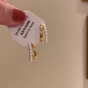 Double-layered gold C-shape hoop earrings with pearls and 925 silver needle on a display card