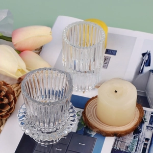 Détail de bougeoirs en verre strié à double usage avec bases ondulées haute et courte