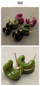 Dettaglio di orecchini a C in smalto colorato con bordo dorato per stile minimalista