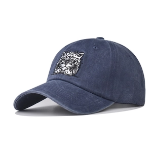 Washed dark blue baseball cap featuring a white and black embroidered cat face on the front