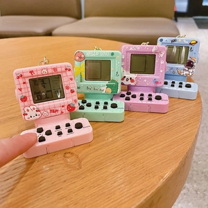 Detailed view of mini retro handheld game console keychains in pastel colors with cartoon art