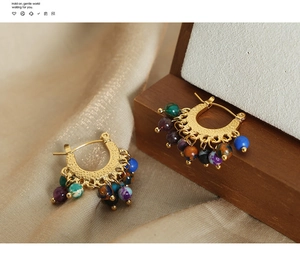 Vue macro détaillée de boucles d'oreilles vintage dorées avec perles d'agate colorées