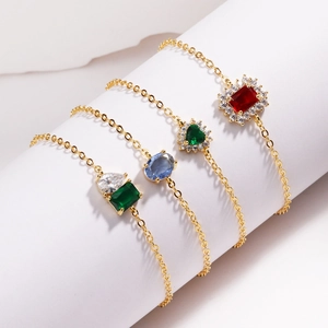 Détails de bracelets dorés ornés de zircons rouges, verts et bleus de style moderne