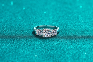 Macro shot of silver S925 ring with three round moissanite stones in a classic prong setting