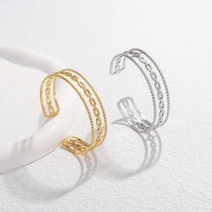 Detail view of gold and silver steel chain bracelets with layered bead accents