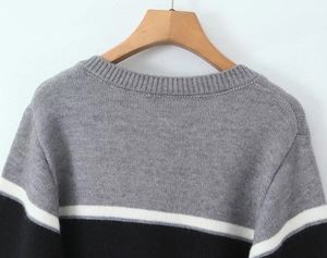 Détail du cardigan en maille à col rond avec motif à rayures gris, noir et blanc