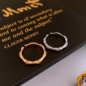 Vue macro de bagues style bambou en or et argent serties de zircons sur fond sombre