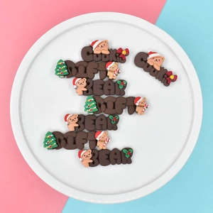 Cute Christmas themed resin charms featuring bear and cookie text designs on a white plate