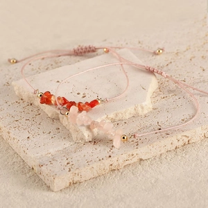 Detailed view of woven bracelets with natural stones and adjustable pink cords