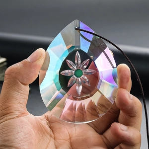 Macro view of teardrop crystal prism with rainbow coating and floral engraving detail