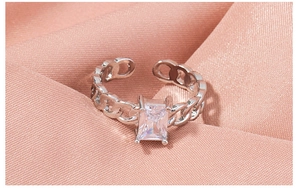 Macro shot of silver chain-link ring with a rectangular clear zircon in four-prong setting