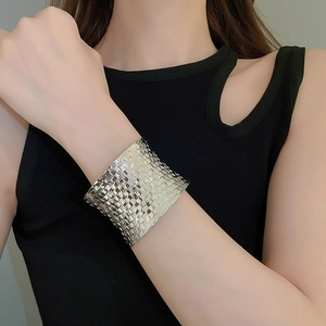 Detailed view of wide silver woven textured cuff bracelet worn on a female model
