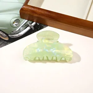 Detail of pale green translucent hair claw clip with pearlescent finish and cloud texture