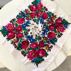 Detailed overhead shot of square white floral scarf with roses and ethnic pattern