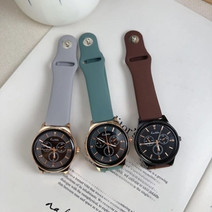 Detail of quartz sport watches with silicone straps in grey, green and brown colors