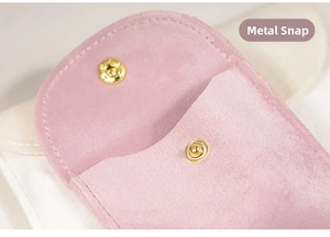 Macro detail of soft pink jewelry pouch with golden metal snap button closure