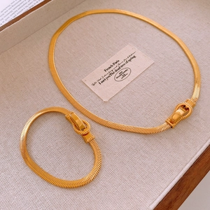 Détail du collier et bracelet chaîne serpent dorée avec boucle magnétique fer à cheval