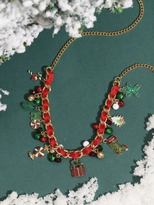 Close-up of Christmas charm bracelet with red ribbon, bells and gingerbread man charms