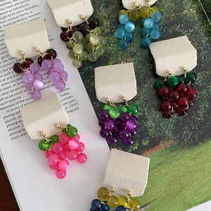 Detail view of multiple colorful grape-shaped resin tassel stud earrings on display cards.