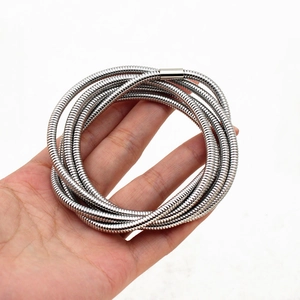Macro detail of silver stainless steel 5-layer spring bracelet with snake chain texture