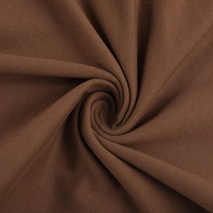 Gros plan détaillé du tissu en maille marron café montrant texture et drapé élégant