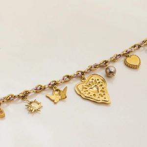 Gros plan d'un bracelet doré avec cordon violet et plusieurs breloques en cœur