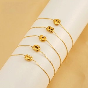 Detailed view of 18K gold plated stainless steel bracelets with 3D initial pendants A to E