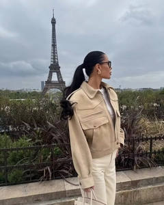 Détail de la veste en daim beige avec col et poches cargo devant la Tour Eiffel
