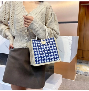 Detail of blue and white houndstooth canvas tote bag with wooden button and rope handle