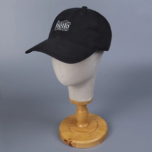 Detalle del bordado blanco 'hello' en una gorra de béisbol de algodón negro lavado