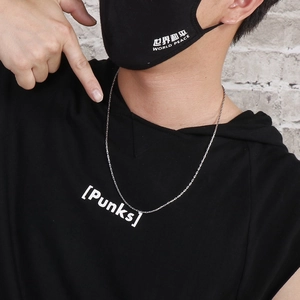 Close-up of a silver stainless steel chain necklace worn by a model with a lobster clasp