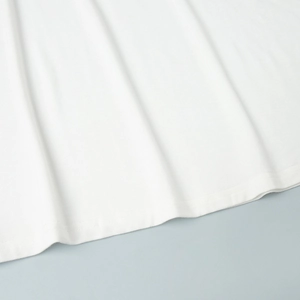 Gros plan de l'ourlet de robe en satin blanc avec double piqûre de précision