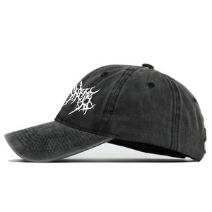 Washed black cotton baseball cap with white gothic embroidery shown in side view